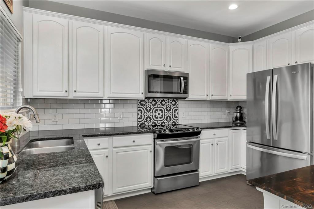 5548 Alexandrite Way, Unit 422 Fort Mill, SC 29708 - Photo 9 of 35 a kitchen with granite countertop white cabinets and stainless steel appliances