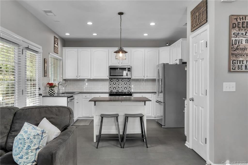5548 Alexandrite Way, Unit 422 Fort Mill, SC 29708 - Photo 10 of 35 a kitchen with stainless steel appliances granite countertop a refrigerator a sink dishwasher a dining table and chairs with wooden floor