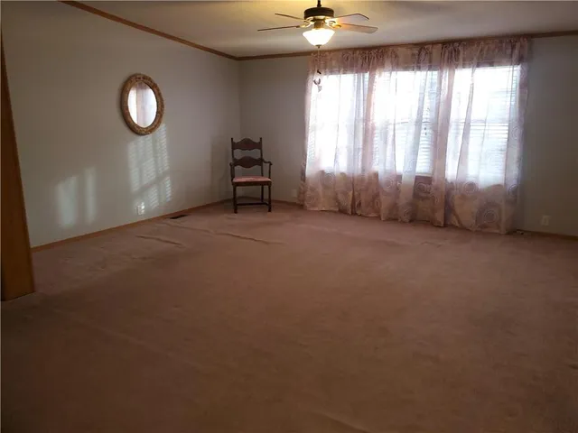 an empty room with a window and a fan
