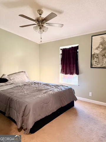 a bedroom with a bed and ceiling fan