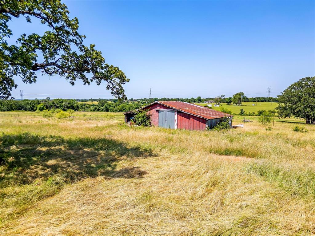 210 Trails End Poolville, TX 76487 - Photo 9 of 25 View of yard with a pole building, a rural view, and an outbuilding