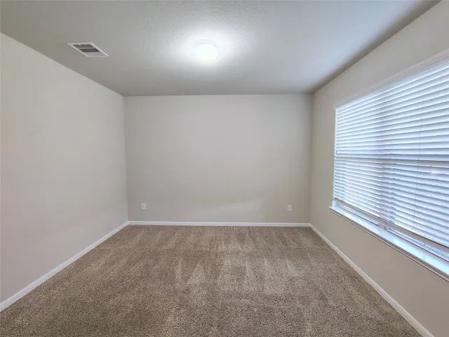 a view of a big room with wooden floor and windows