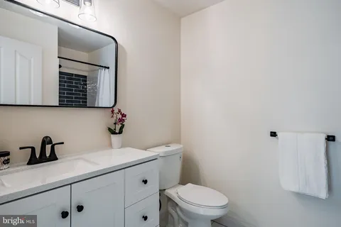 a bathroom with a toilet a sink and mirror