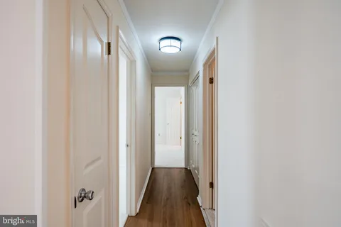 a view of a hallway with wooden floor and staircase