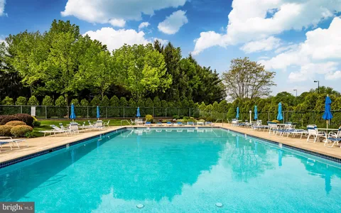 a view of a swimming pool with a yard and sitting area