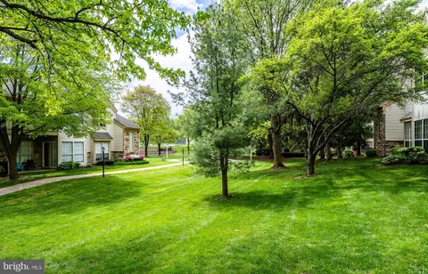 a view of a house with a big yard and large trees