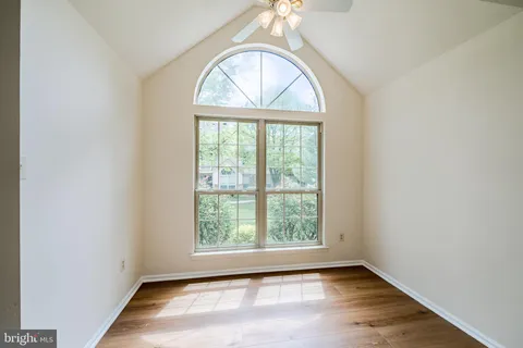 an empty room with wooden floor and a window