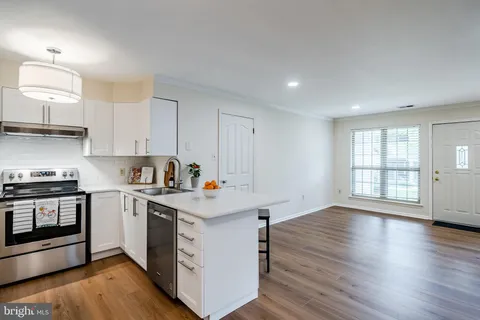 a kitchen with a sink a stove and cabinets