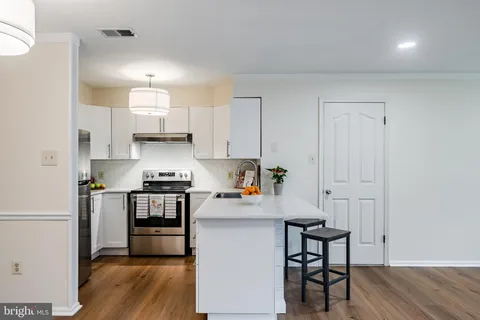 a kitchen with stainless steel appliances a stove a sink cabinets and a refrigerator