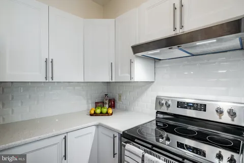 a kitchen with a stove a microwave and cabinets