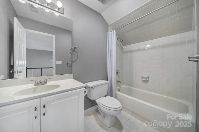 a bathroom with a toilet sink vanity tub and shower