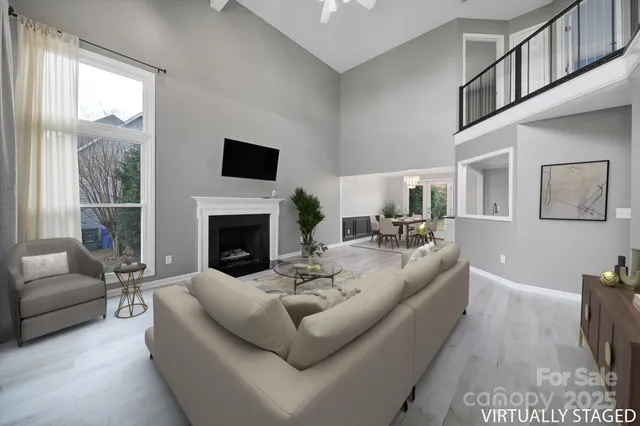 a living room with furniture fireplace and a large window