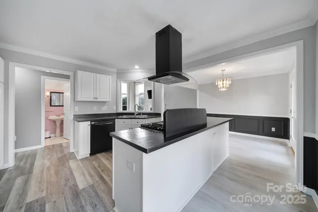 a kitchen with stainless steel appliances kitchen island a stove and a sink