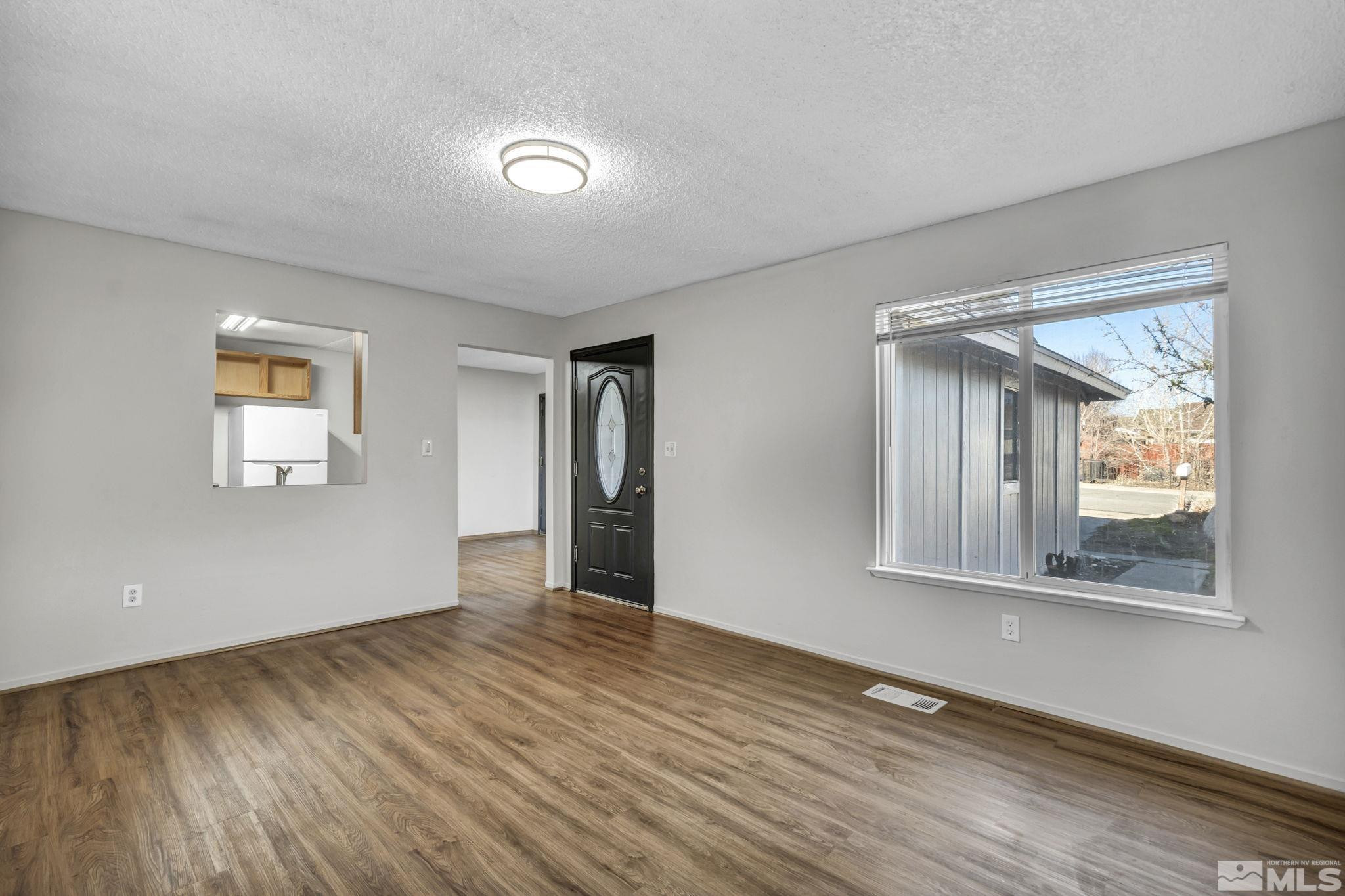 6550 Fern Street Reno, NV 89506 - Photo 3 of 19 a view of an empty room with wooden floor and a window