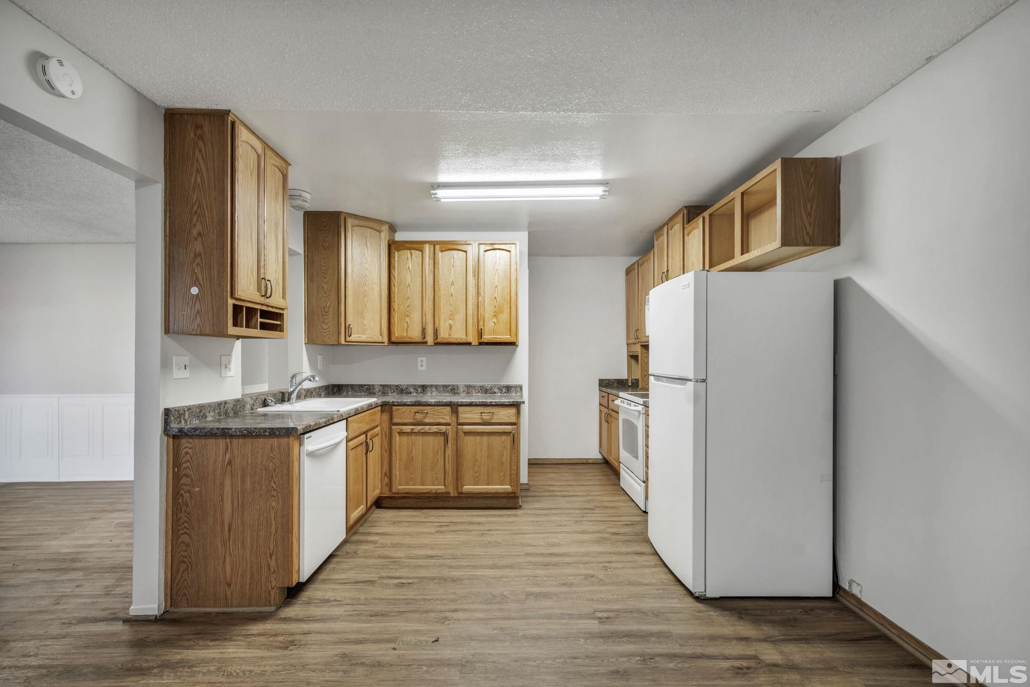 6550 Fern Street Reno, NV 89506 - Photo 5 of 19 a kitchen with a refrigerator a stove top oven a sink and dishwasher
