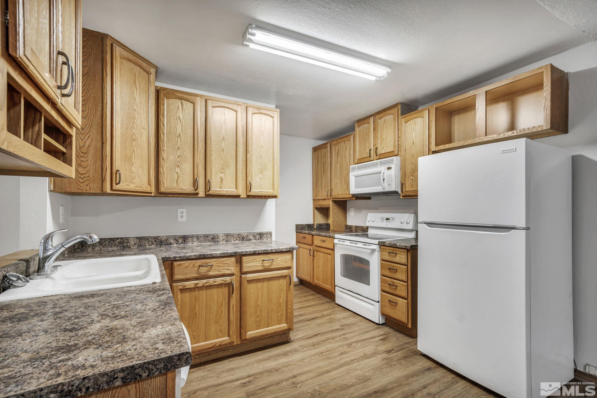 6550 Fern Street Reno, NV 89506 - Photo 6 of 19 a kitchen with a refrigerator a stove a sink and cabinets