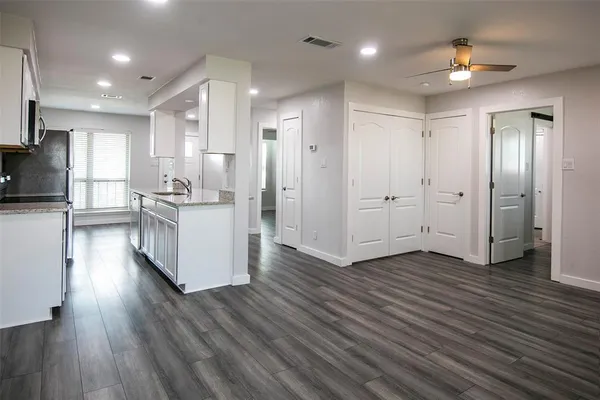 a living room with stainless steel appliances kitchen island furniture and wooden floor