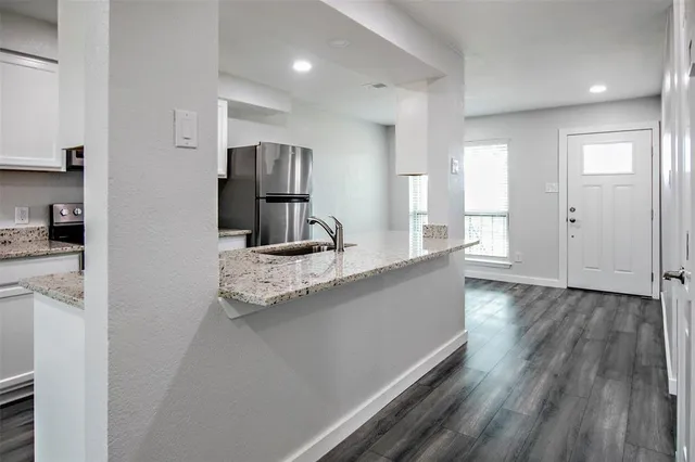 a kitchen with stainless steel appliances granite countertop a refrigerator and a sink