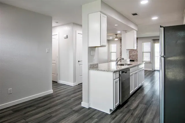 a kitchen with a refrigerator sink and cabinets