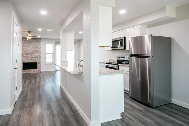 a kitchen with stainless steel appliances a refrigerator and a stove top oven
