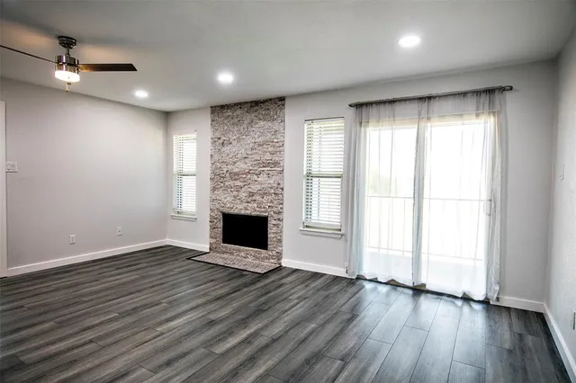 a view of empty room with wooden floor and fireplace