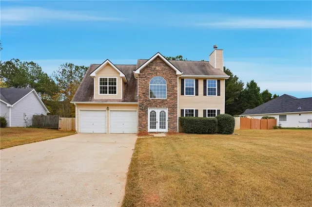 a front view of a house with a yard and garage