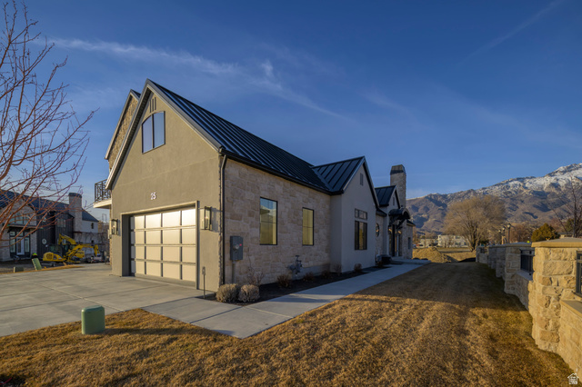 250 South Main Street, Unit 25 Alpine, UT 84004 - Photo 2 of 31 View of side of home featuring a standing seam roof, stone siding, driveway, stucco siding, and a mountain view