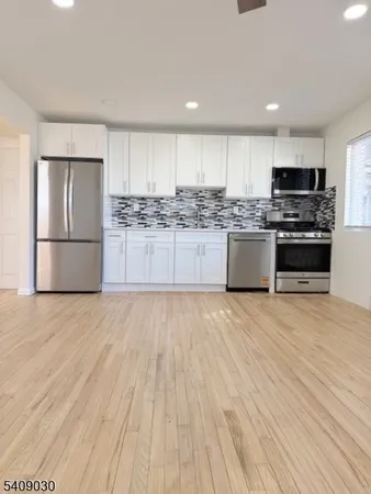a kitchen with stainless steel appliances granite countertop a refrigerator sink and stove