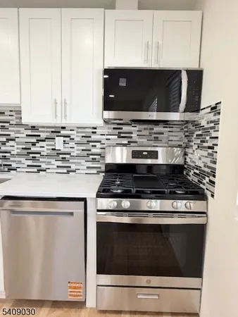 a stove top oven sitting inside of a kitchen