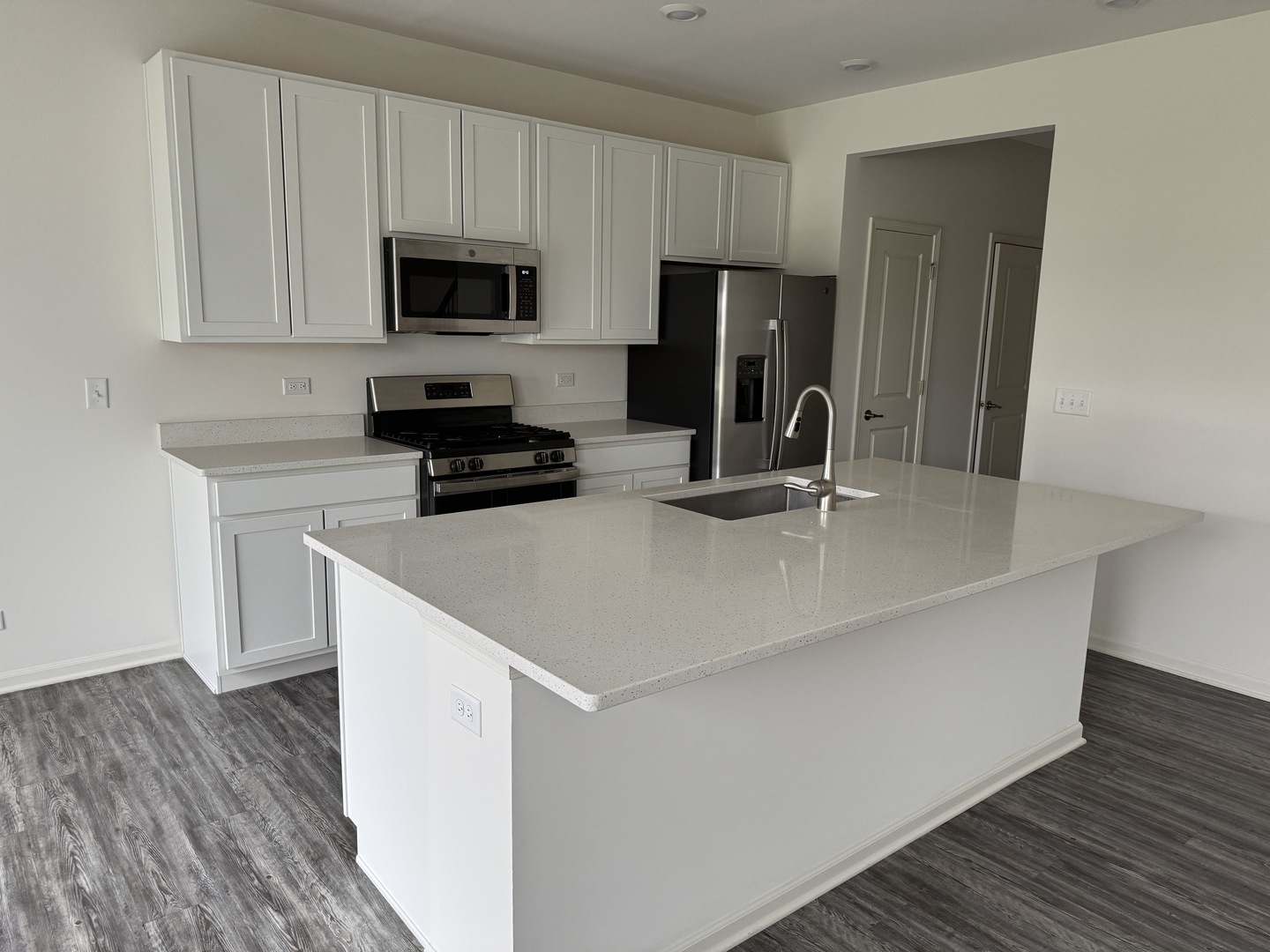 1226 Draper Road McHenry, IL 60050 - Photo 3 of 17 a kitchen with a sink a microwave a refrigerator and cabinets
