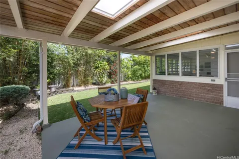 a view of a backyard with potted plants and large trees