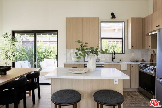 a dining room with kitchen island furniture a large window and kitchen view