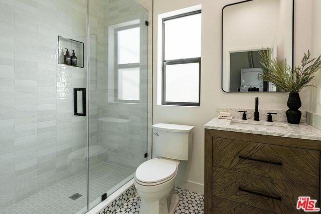 a bathroom with a granite countertop sink toilet and shower