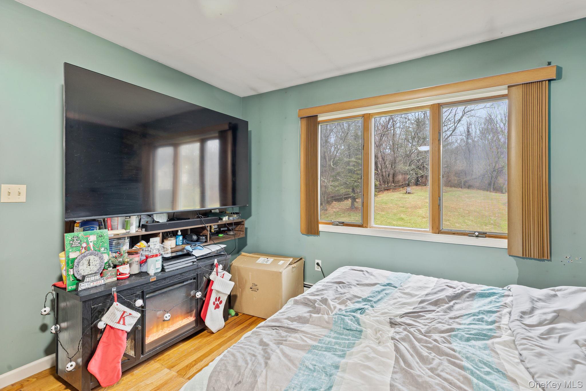 11 Cross Creek Road Cold Spring, NY 10516 - Photo 28 of 43 a bedroom with a bed a large window and flat screen tv