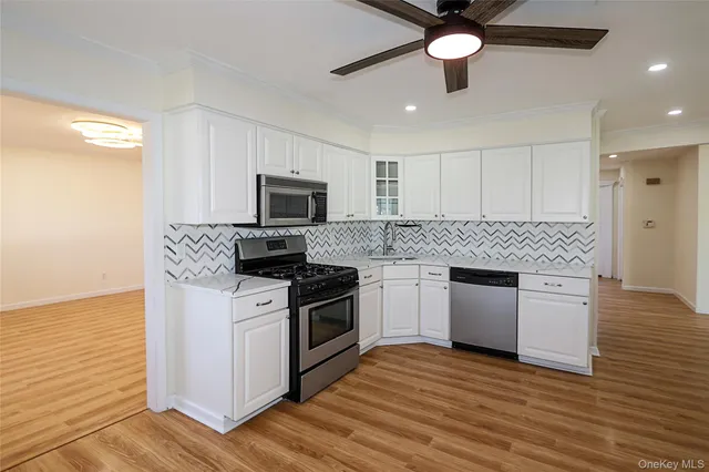 a kitchen with granite countertop a stove cabinets and wooden floor