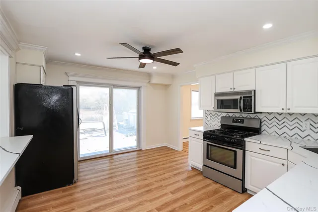 a kitchen with granite countertop a refrigerator a stove top oven a sink and dishwasher with wooden floor