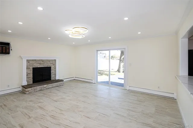 an empty room with windows and fireplace