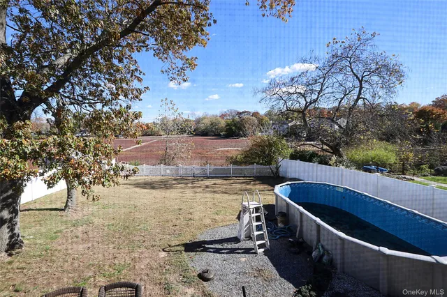 a view of a swimming pool with a yard and seating area