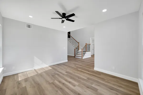 a view of a room with wooden floor and ceiling fan