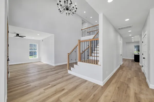 a view of a hallway with wooden floor and staircase