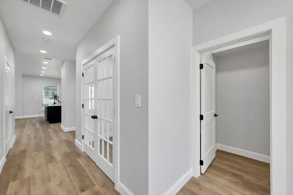 a view of a hallway with a dining table & a mirror