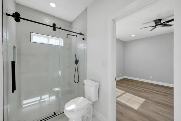 a view of empty room with wooden floor and ceiling fan