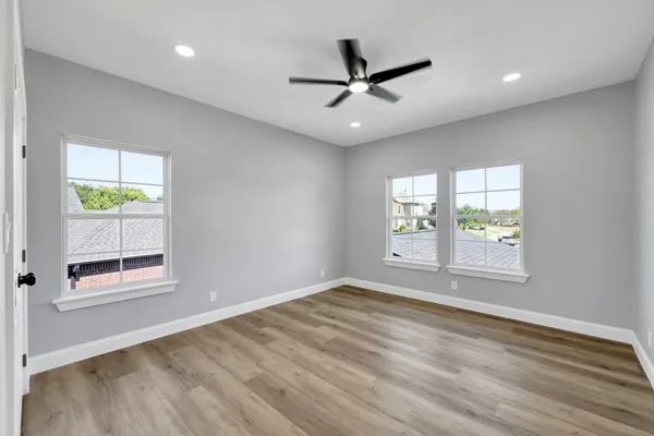 wooden floor in an empty room with a ceiling fan