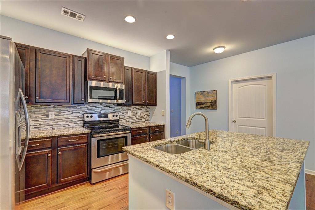 505 Riverview Lane Canton, GA 30114 - Photo 11 of 34 a kitchen with kitchen island granite countertop a stove sink and microwave