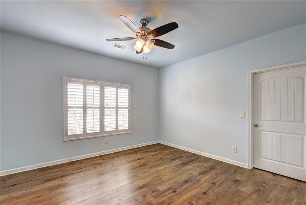 505 Riverview Lane Canton, GA 30114 - Photo 23 of 34 an empty room with wooden floor fan and windows