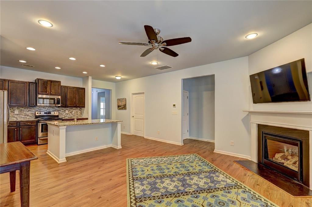 505 Riverview Lane Canton, GA 30114 - Photo 5 of 34 a living room with stainless steel appliances furniture a fireplace a flat screen tv and a window