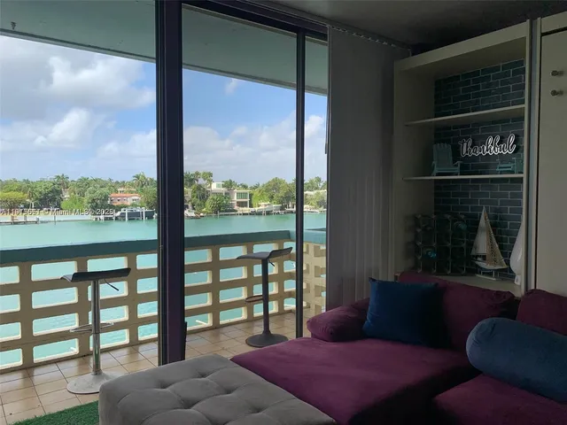 a bedroom with furniture and a large window