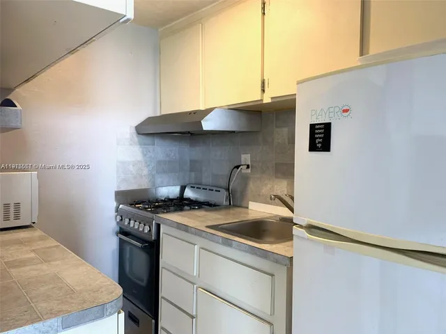 a kitchen with stainless steel appliances a sink a stove and a refrigerator