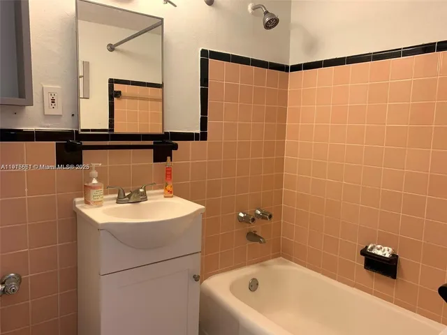 a bathroom with a sink a toilet a mirror and bathtub
