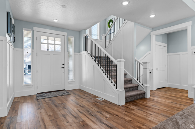 1426 South 1450th Street West Mapleton, UT 84664 - Photo 3 of 50 Spacious entry featuring wood-finish flooring, white board and batten wall details, and a staircase with wrought iron balusters